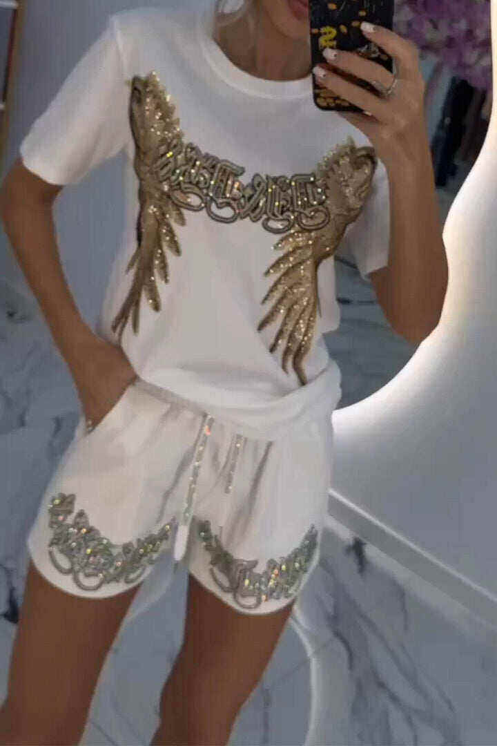 Conjunto feminino composto por top e shorts com estampa de penas brilhantes